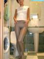 Shorthaired nude model poses in glossy pantyhose